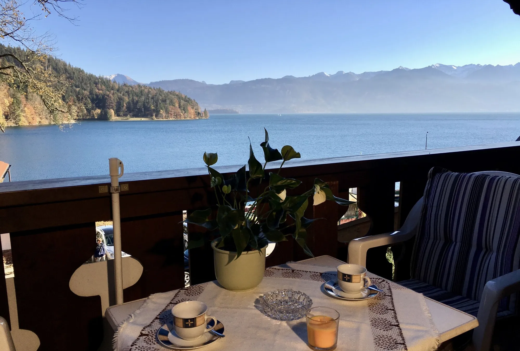 Echtes Foto vom Balkon im Haus Asenstorfer: Tisch mit Kaffeetassen, dahinter der See